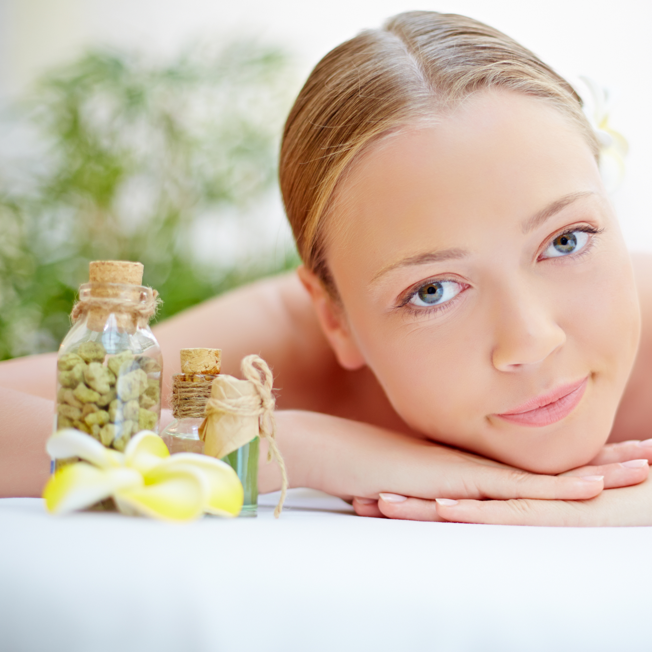 Une femme sur une table de massage avec des produits naturels et bio