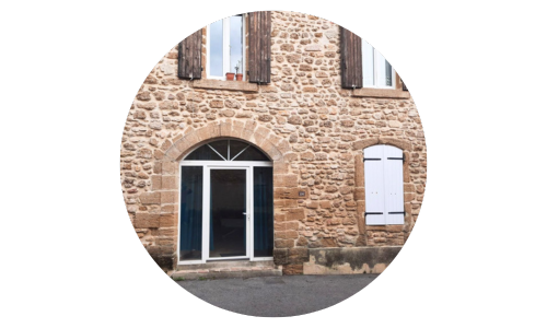 photo de l'entrée de l'institut avec sa porte en forme d'arche, mur à l'ancienne en pierres apparentes.
